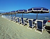Empty Sun Loungers And Umbrellas On Beach