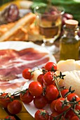 Prosciutto-Schinken, Käse, Tomaten, Weißwein, Brot und Olivenöl, Nahaufnahme