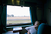Frau schaut aus dem Fenster eines Zugwagens