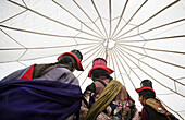 Ladakhische Frau in traditioneller Kleidung und mit Hut tanzt unter einem traditionellen Zelt