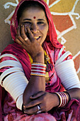 Porträt einer lächelnden Frau im rosa Sari