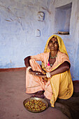 Frauen in gelben Sari mit Schüssel mit Essen