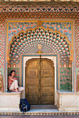 Frau mit Rucksack sitzt im dekorierten Eingangsbereich der Tür des Stadtpalastes