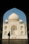 Silhouette Of Woman With Rucksack In Archway Admiring The Taj Mahal