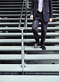Geschäftsmann geht eine Treppe hinunter, London