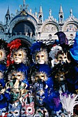 Karnevalsmasken an einem Stand, Markusplatz mit Basilika im Hintergrund