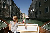 Frau sitzt in einem Wassertaxi, Venedig