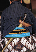 Mann in Zeremonienkostüm mit Schwert in Schärpe