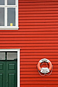 Life Ring Hanging On Red Clapboard House