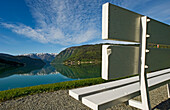 Leere weiße Bank am Fjord