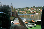 A Woman Passenger River Cruise Takes A Photograph Of The Scenery