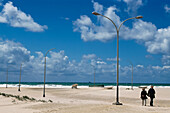 Couple Holding Hands Walking On Beach