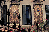 Ornate Building With Paintings Between Windows