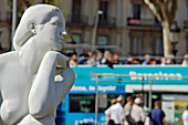 Eine Statue starrt auf einen Bus voller Touristen