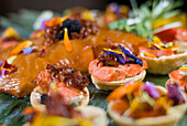 Close Up Of Smoked Copper River King Salmon Tart With Carmelized Onions, Goat Cheese, Sun Dried Chukar Cherries, Sherry Reduction, Shaved Truffle, And Wildflowers