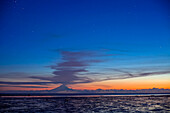 Aschewolke steigt bei Sonnenuntergang während der Ebbe in der Nähe von Ninilchik, Alaska, vom Mt. Redoubt auf