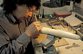 Einheimischer Elfenbeinschnitzer aus Alaska bei der Arbeit an einem Stück Ak Studio/Njohn Koschman