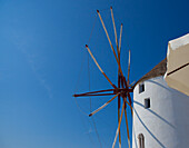 Windmühle und ein weißes Gebäude vor blauem Himmel; Oia, Griechenland