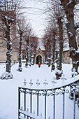 Mädchen, das im Schnee einen Weg zu einer Kirche hinaufgeht; Great wilbraham cambridgeshire england