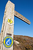 A wooden post and directional sign for a Wales Coast Path; Wales