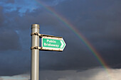 Ein Regenbogen durch die Sturmwolken und ein Hinweisschild auf einen öffentlichen Reitweg; Hertfordshire, England