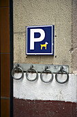 Ein witziges Schild zum Parken oder Anbinden von Haustieren an einem Metallring an der Wand; Barcelona, Spanien