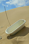 Badewanne eines verlassenen Hauses, das von den vorrückenden Sanddünen der Namib-Wüste eingenommen wurde; Kolmanskop, Luderitz, Namibia