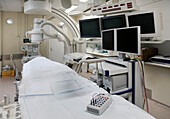Ein modernes Krankenhauszimmer, eine große tragbare mobile Scannermaschine mit gebogenen Armen und mehreren Bildschirmen für die medizinische Bildgebung. 