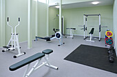 Ein Fitnessraum, Fitnessgeräte, Gewichte und Fitness- und Sporttrainingsgeräte, in einer Schule. 