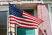 American flag in front of a building, a shop window on main street. 