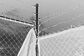 Stock photo of barbed wire fence and draped fabric.