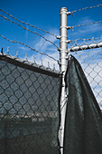 A barbed wire fence and draped fabric