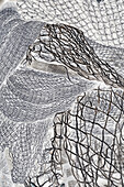 Ein Haufen kommerzieller Fischernetze, monochromes Bild. 