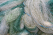 Ein Stapel kommerzieller Fischernetze, blau-grün-weiß. 