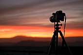 A Camera Set On A Tripod Aimed At A Silhouette Of A Landscape At Sunset; San Pedro De Atacama, Antofagasta Region, Chile