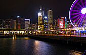 Hongkong, China. Nächtliche Skyline mit neuem Riesenrad und Dämmerung in der Stadt am Hafen und Hong Kong Observation Wheel in lila