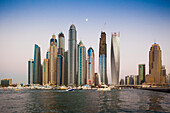 UAE, Dubai Marina high-rise buildings including the twisted Cayan Tower, with moonrise