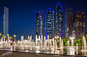 UAE, Abu Dhabi. Emirates Palace Hotel fountains and Etihad Towers