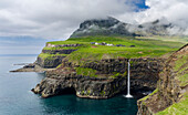 Wasserfall in der Nähe von Gasadalur, eines der Wahrzeichen der Färöer Inseln. Insel Vagar, Teil der Färöer Inseln im Nordatlantik. Dänemark