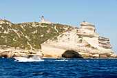 Europa, Frankreich, Korsika, Bonifacio. Boot passiert den Leuchtturm von Capo Pertusato