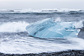Europe, Southwest Iceland, Skaftafell National Park. Chunks of ice from the Breioamerkurjokull Glacier are caught in the surf below Jokulsarlon.