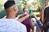 Junge Freunde trinken Bier, während sie im Park stehen