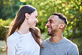 Lächelndes junges Paar, das sich in einem öffentlichen Park ansieht