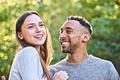 Smiling young couple sitting in public park