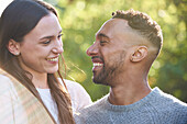 Nahaufnahme eines lächelnden jungen Paares, das sich in einem öffentlichen Park ansieht