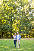 Lächelndes junges Paar hat Spaß beim Spaziergang im Park