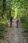 Young couple cycling in forest