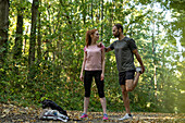 Junges Paar, das auf einem Waldweg trainiert