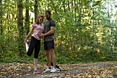 Young couple exercising on dirt track in forest