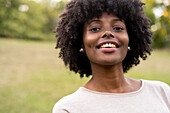 Close-up of smiling young woman standing in park